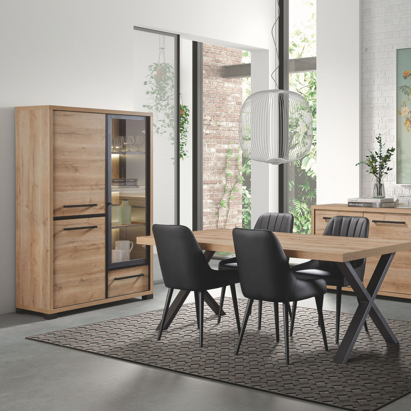 Salle à manger Rico (bi-ton Arizona Oak & Nero), vitrine LED éclairée et table à manger avec chaises noires en ambiance