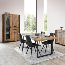 Salle à manger Onno (décor TROPIX), table dressée avec chaises noires entre la vitrine et le bahut, en ambiance lumineuse