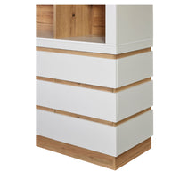 Rangement Urbino en panneaux revêtus WIT (blanc), détail de l'angle du buffet avec tiroirs blancs superposés, rainures en chêne et socle assorti